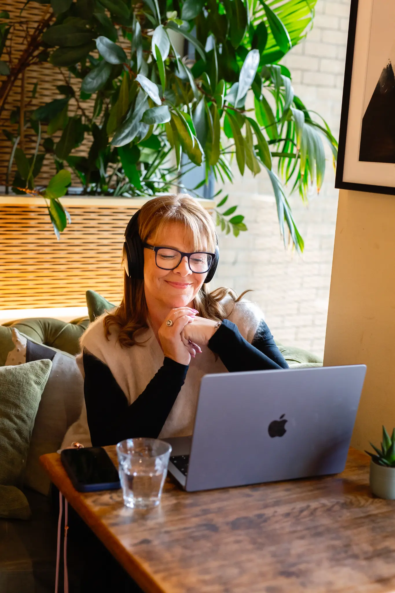 Mel Harris podcasting with headphones and a laptop